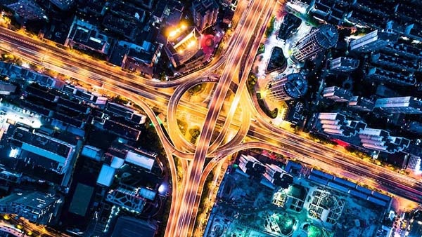 Nighttime aerial view of a freeway intersection with cars