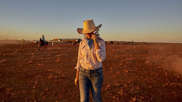 A woman uses a mobile phone in the Australian Outback