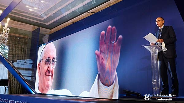 Event stage with an image of the Pope on-screen