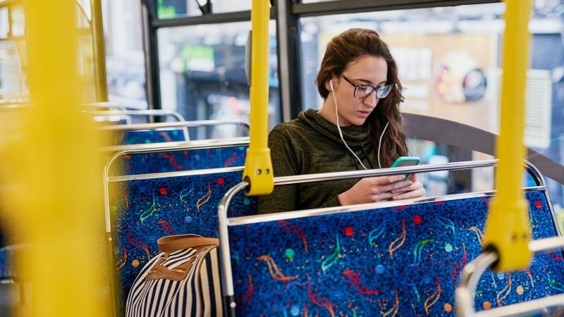 Image of a public transportation passenger looking at a mobile device