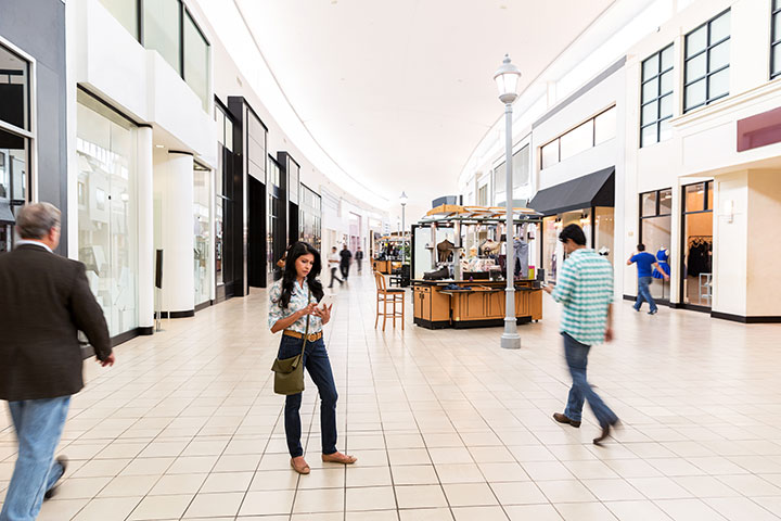 Woman looking at phone in a mall