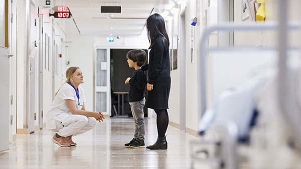Professionnel de santé discutant avec des patients dans un couloir