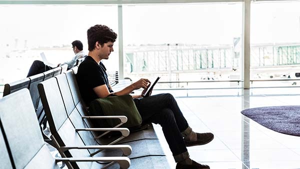 Man sitting in airport using tablet device
