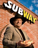 Les White holds a sub in front of one of his franchises