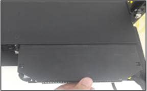 A hand holding a black rectangular objectDescription automatically generated