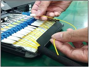 A close-up of a hand holding a cableDescription automatically generated