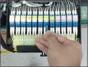 A hand pointing at a cableDescription automatically generated with medium confidence