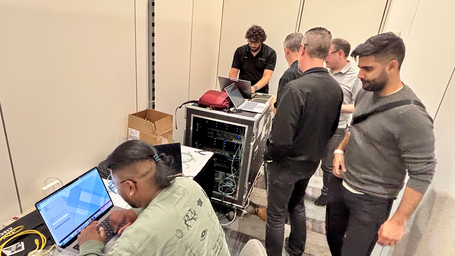A group of people standing around a computerAI-generated content may be incorrect.