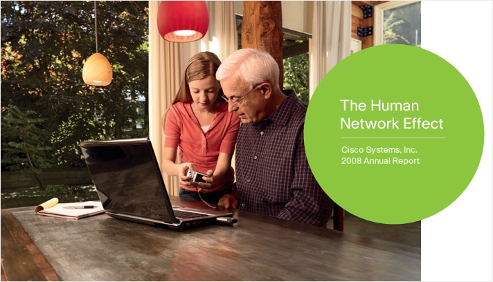 The Human Network Effect Cisco Systems, Inc. 2008 Annual Report Photo of a granddaughter showing her grandfather how to download photos from a digital camera onto a laptop computer in a home dining room.