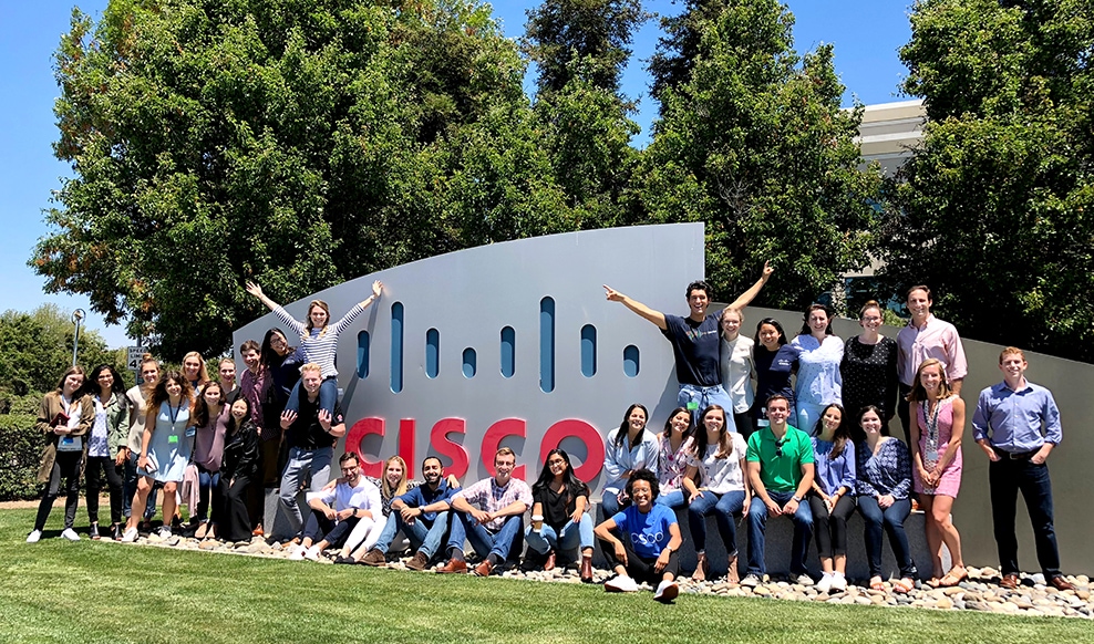 Large group of people in front of a Cisco sign.