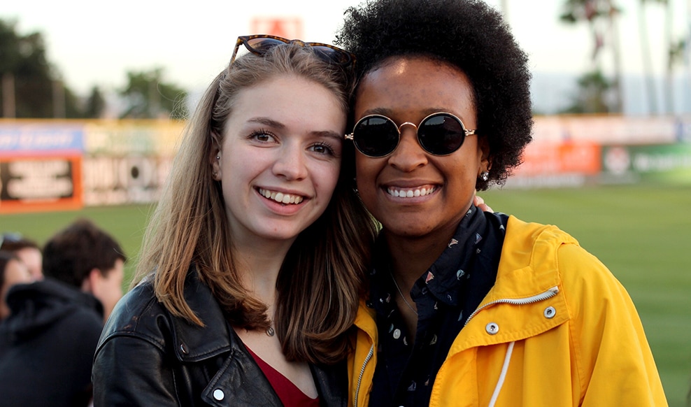 Two people standing next to each other smiling.