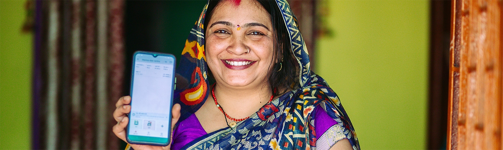 Smiling female entreprenuer holds mobile phone