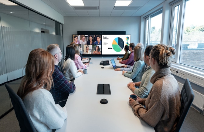 The Cisco Room Kit EQX wall-mount model deployed with carbon black Table Microphone Pro units in a conference room