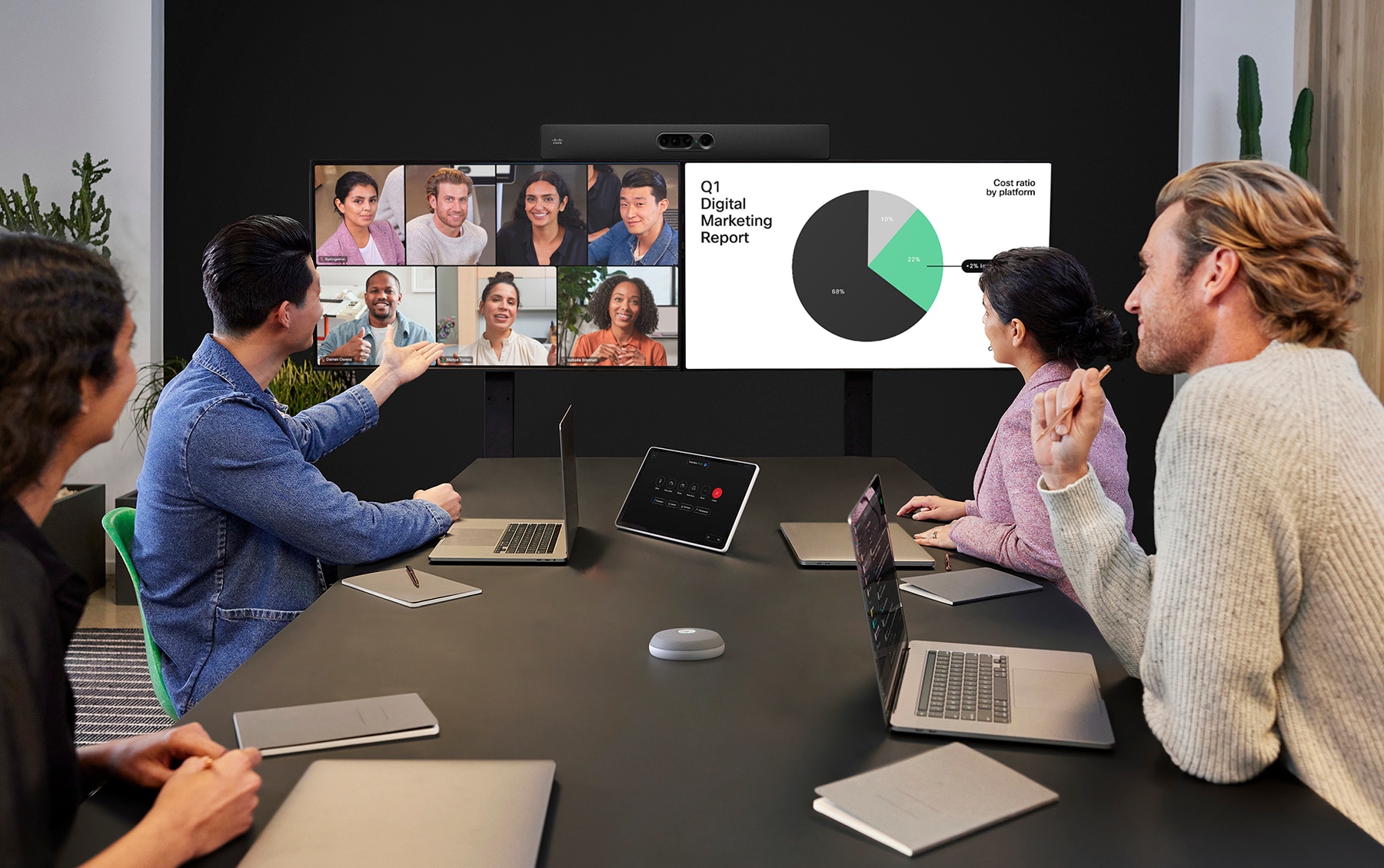 Cisco Room Navigator table-stand panel used as a room control device in a meeting room, running on RoomOS
