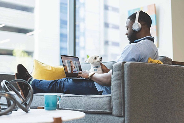 Homem usando fone de ouvido Cisco e trabalhando em um notebook