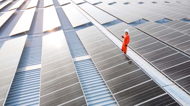 Solaranlagen und ein Mitarbeiter in einem Solarkraftwerk