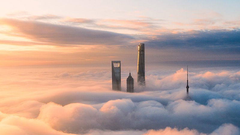 Die Spitzen von Wolkenkratzern werden über den Wolken sichtbar