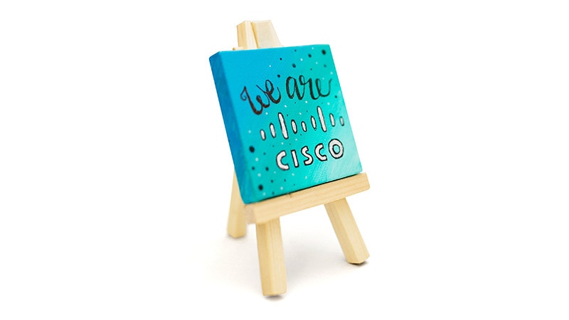 Blue “We are Cisco” painting on a wooden easel.
