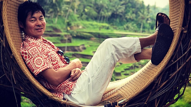 Male based in Japan office, relaxing in circular woven outdoor chair in Bali