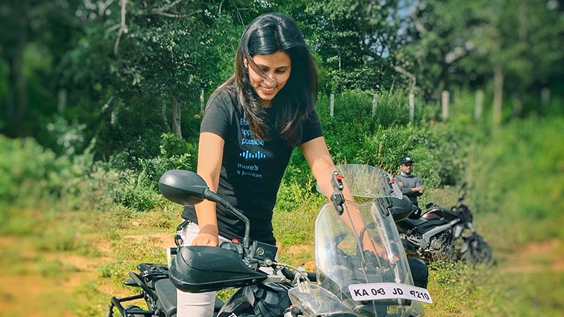 Female wearing Cisco shirt, Between hope and possible, theres a bridge shirt, sitting on a motor dirt bike in India.