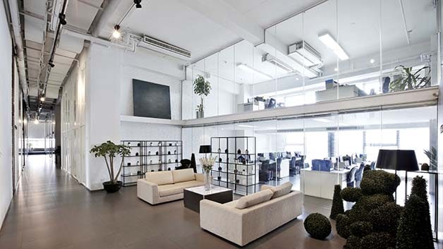 Modern, open concept office space with sitting area and glass walls