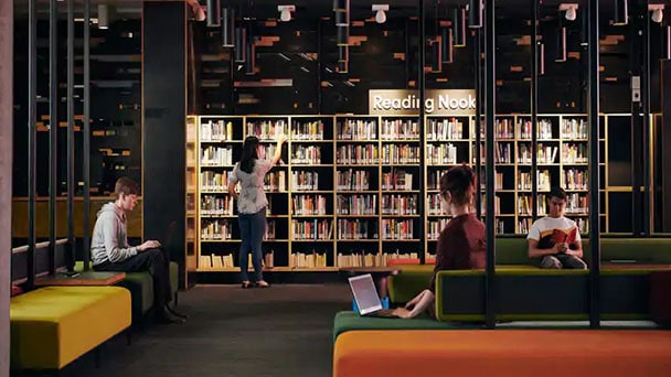 Students reading and working in a library