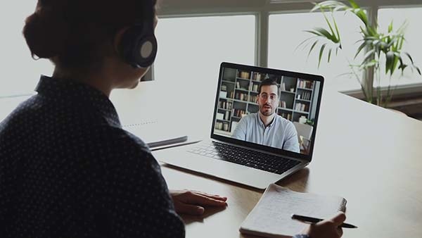 Woman uses video conference with a male colleague