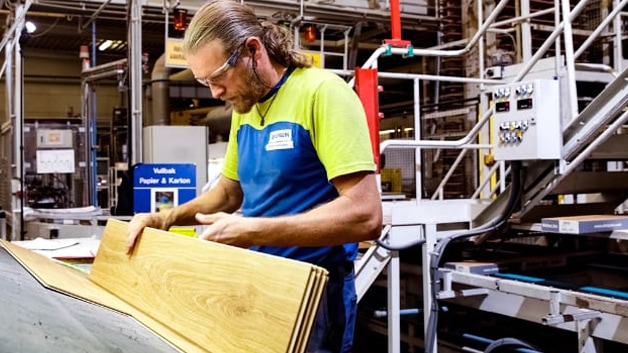 Unilin worker examining planks of wood flooring