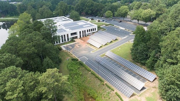 Building surrounded by solar panels and trees