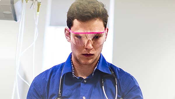 Three individuals in a lab setting with protective eye-gear