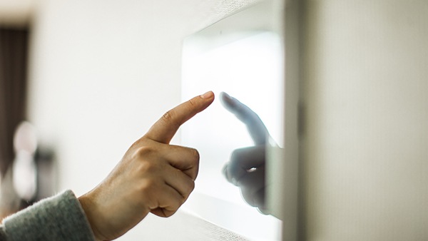 Index finger of a hand touching the surface of a display device