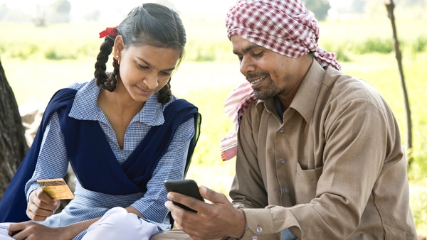 Two people using a smartphone to enhance their economic inclusion. 