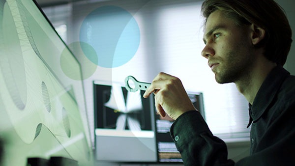 A man thinking seriously as he examines a large screen.