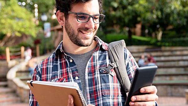 College student accessing class documents on smartphone while walking