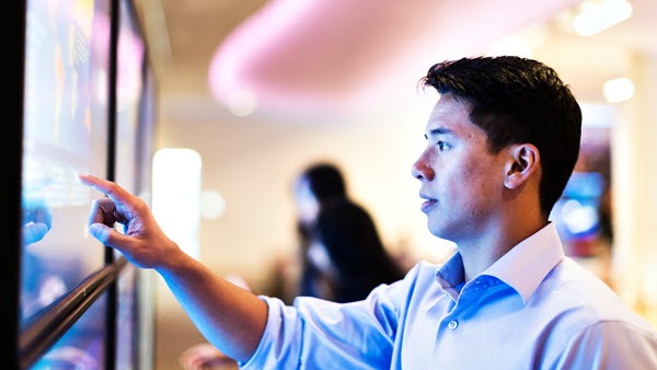 Computer technician standing at a monitor