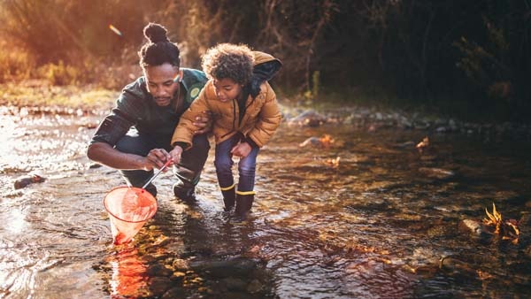 A father and son fishing in a stream