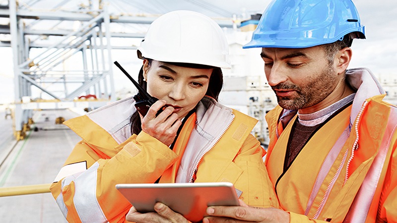 Factory employees checking their devices 