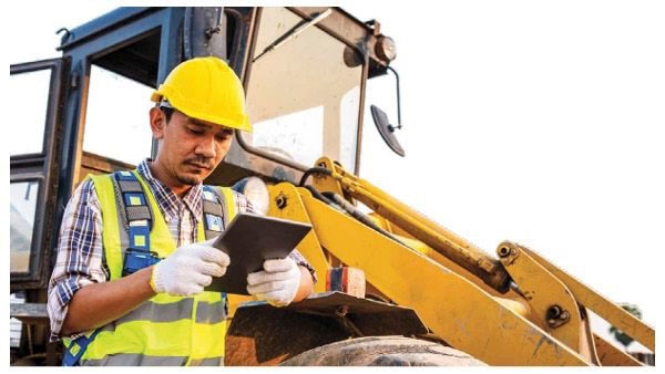 Employee wearing hard hat looking at tablet