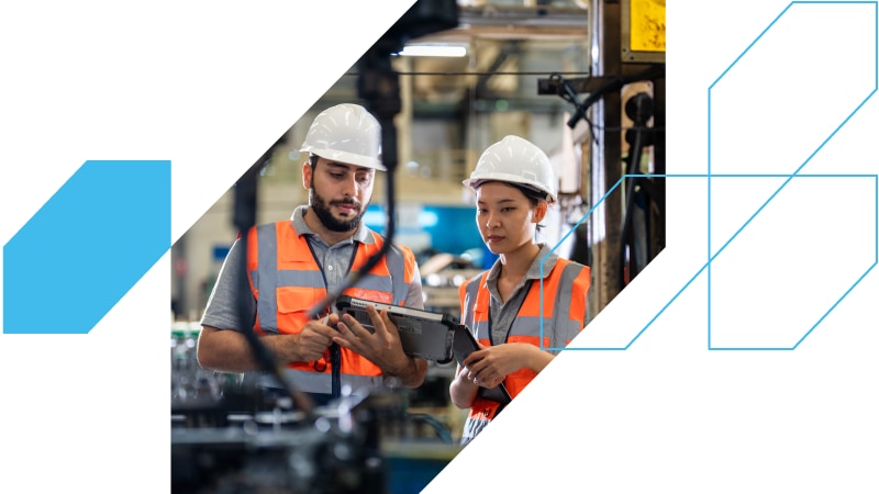 Two manufacturing workers looking at a screen