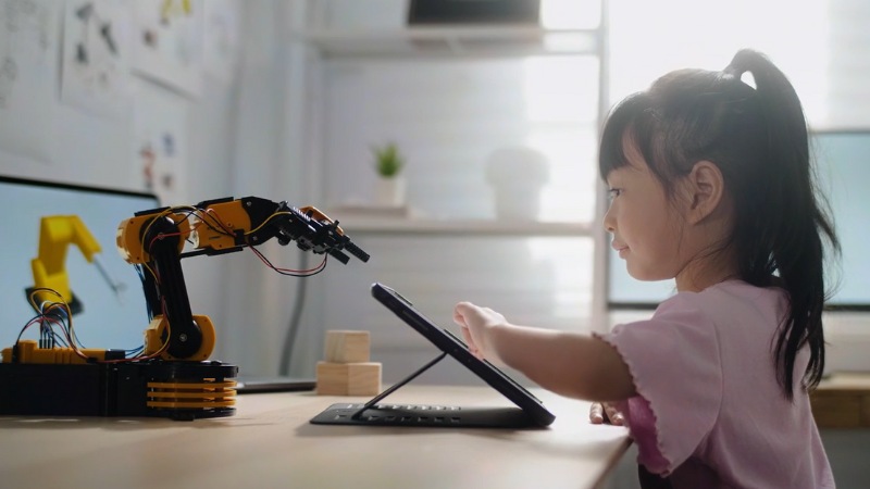 Child on tablet with engineering device in front of them