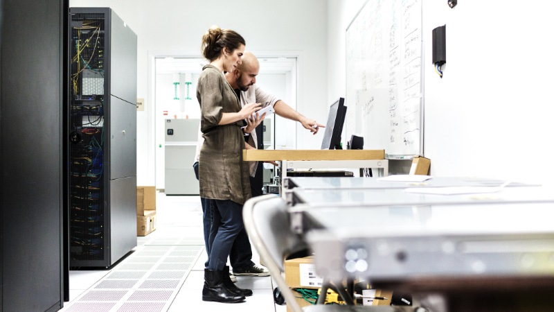 Two people on computer at a data center