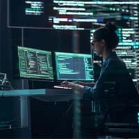 Women sitting at two computer desktops