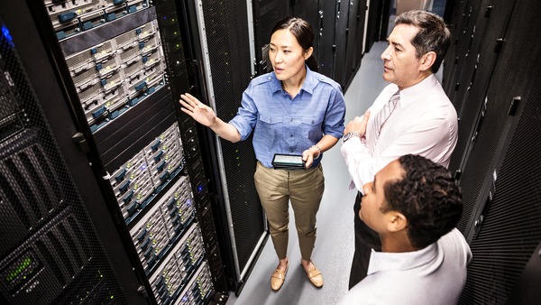 Three colleagues having a discussion inside a data center