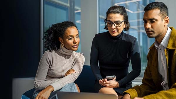 Three people at a computer 