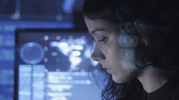 Vista de perfil de una señorita con un monitor de computadora a la distancia