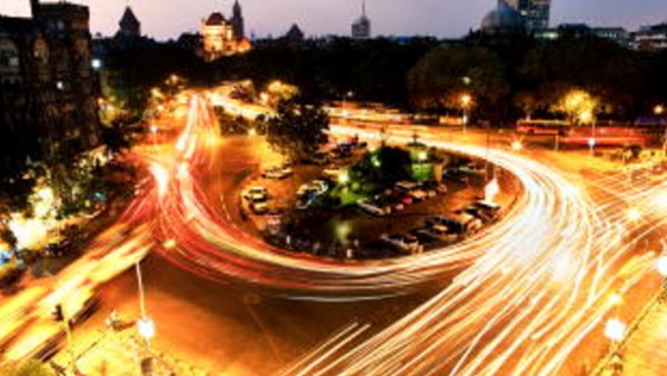 Luces de vehículos moviéndose en un círculo de tránsito en la ciudad a oscuras