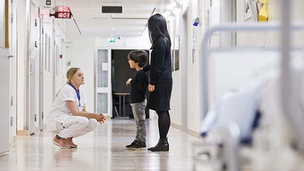 Professionnel de la santé qui parle avec des patients dans le corridor