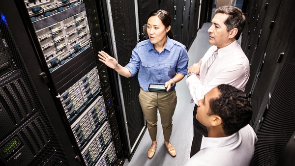 Trois collègues discutent dans un data center