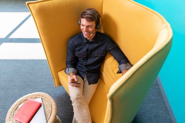 Man sitting in yellow chair with headset