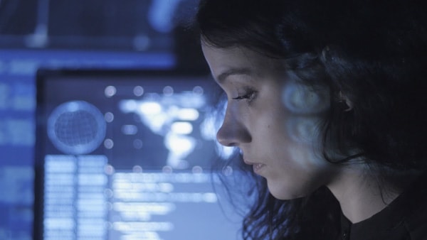 vista laterale di donna con monitor del computer in lontananza